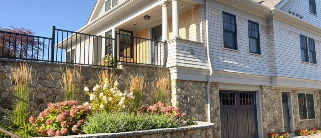 Fieldstone retaining wall with hydrangeas and ornamental grasses at a Cape Cod home